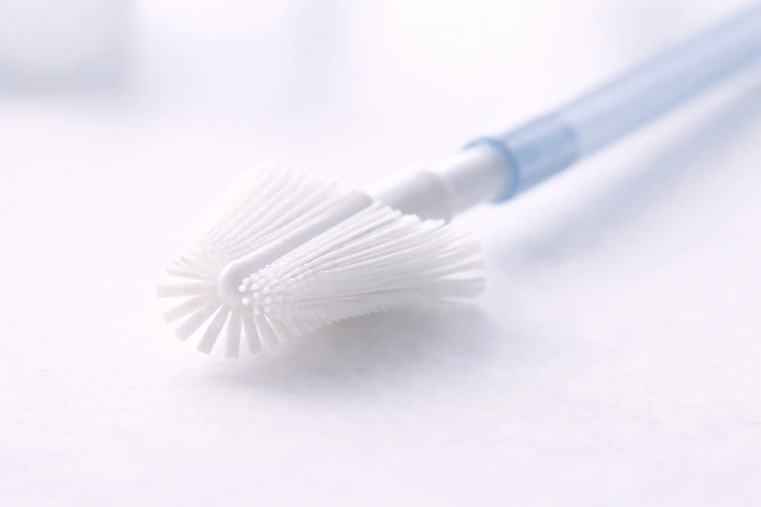 Macro close-up of a modern, soft cervical screening brush (Cervex-brush) used for gentle Pap smear sample collection
